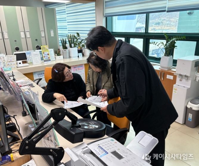 25일 밀양시 상동면행정복지센터 직원이 방문 민원인에게 저소득층 치과 진료비 지원사업을 안내하고 있다.