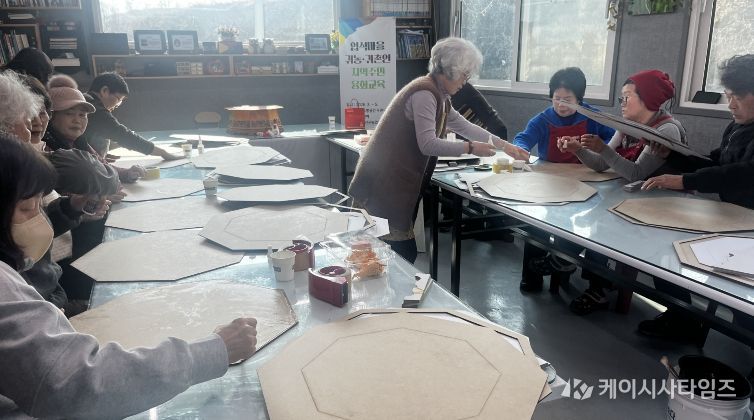 귀농귀촌인과 지역주민이 연풍면 입석마을에서 옻칠한지로 찻상 만들기를 진행하고 있다.