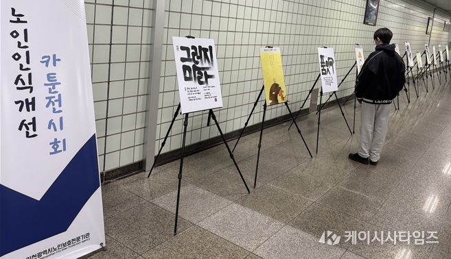 인천지하철 1호선 동춘역을 지나는 한 학생이 인천시노인보호전문기관 ‘노인인식개선 카툰전시회’ 작품을 읽고 있다.